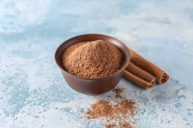 Tarçın tozu ve sopalarla dolu bir kase.