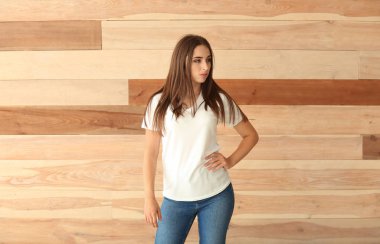 Ahşap duvarının yakınında şık tişört genç kadın
