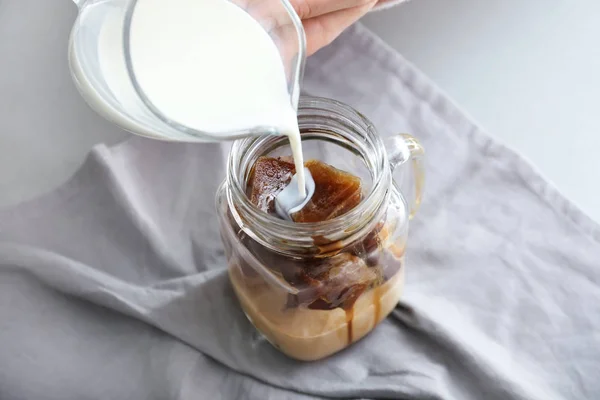 Frau Gießt Milch Einmachglas Mit Kaffeeeiswürfeln Auf Tisch Nahaufnahme — Stockfoto