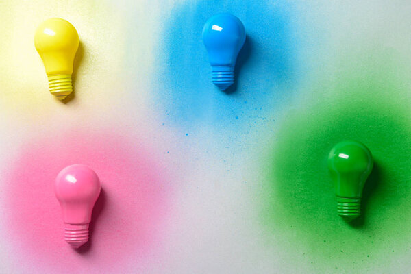 Painted light bulbs on light background