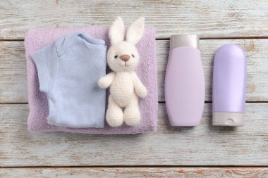 Bebek Giysi, banyo kozmetik, havlu ve oyuncak ahşap arka plan üzerinde