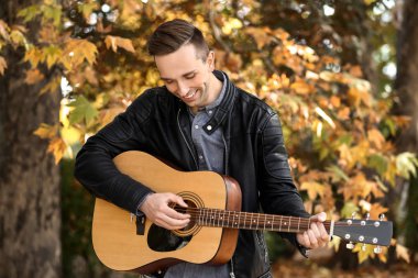 Yakışıklı delikanlı Park'ta dinlenme gitar ile