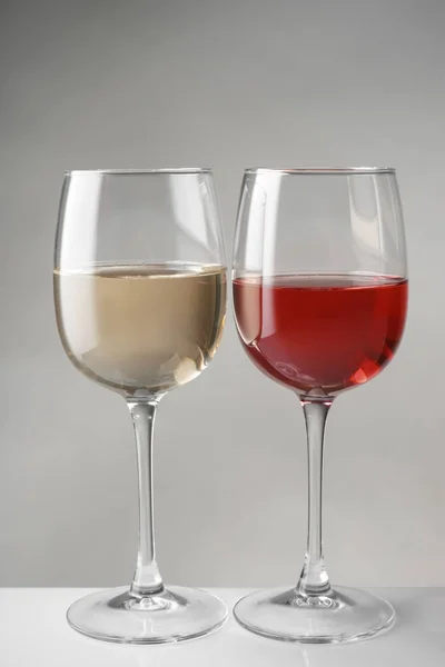 Glasses of expensive red and white wines on table