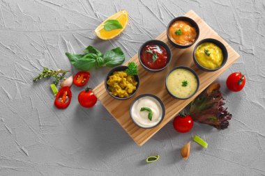 Kase gri arka plan üzerinde farklı lezzetli soslar