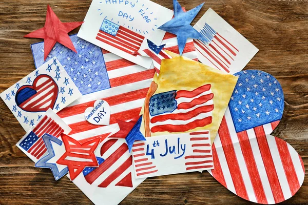 Many paintings of American national flag on wooden table. 4th July celebration