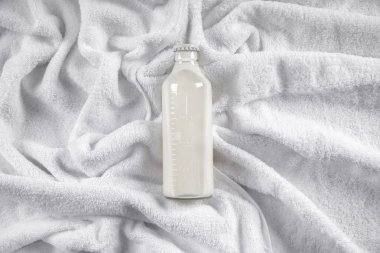 Şişe süt üzerinde yumuşak havlu, üstten görünüm