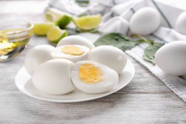 Beyaz ahşap masa üzerinde lezzetli haşlanmış yumurta ile plaka
