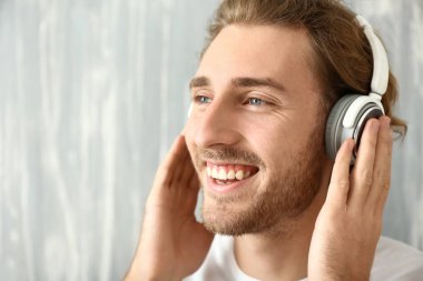 genç adam gri arka plan üzerinde müzik dinlemek