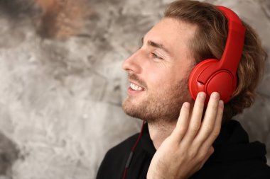 Genç adam grunge arka planda müzik dinlemek