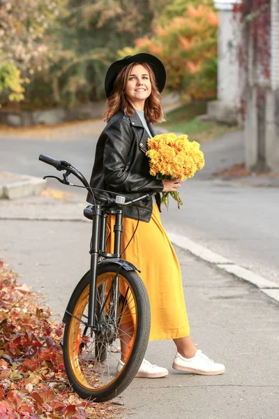 Hermosa Mujer Joven Con Bicicleta Sosteniendo Flores Amarillas Aire Libre — Foto de Stock