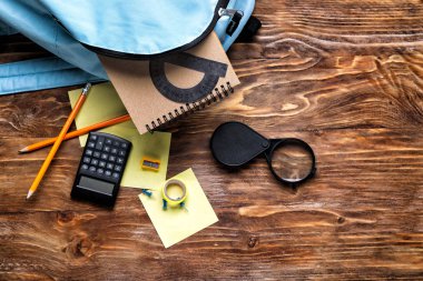 Ahşap arka plan, üstten görünüm üzerinde sırt çantası ve okul Kırtasiye ile kompozisyon