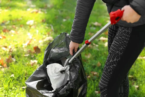 Woman gathering trash in park