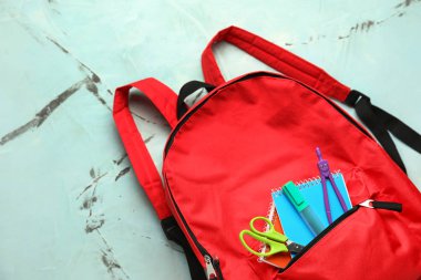 Renk arka plan üzerinde okul Kırtasiye ile şirin sırt çantası