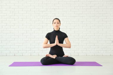 Evde yoga yapan genç bir kadın.