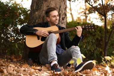 Yakışıklı delikanlı Park'ta dinlenme gitar ile