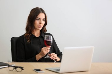 Güzel genç kadın ofiste şarap içme