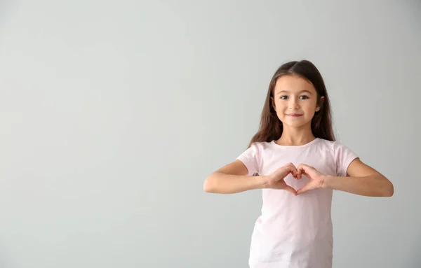 Cute Girl Shirt Making Heart Her Hands Light Background — Stock Photo, Image