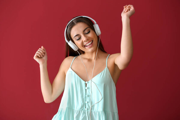 Beautiful woman listening to music on color background