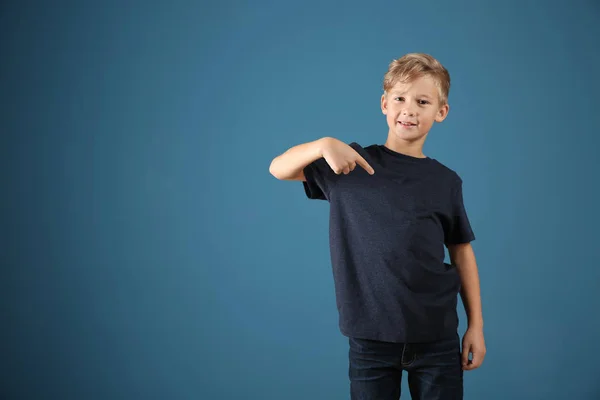 Niedlicher Junge Zeigt Auf Sein Shirt Auf Farbigem Hintergrund — Stockfoto