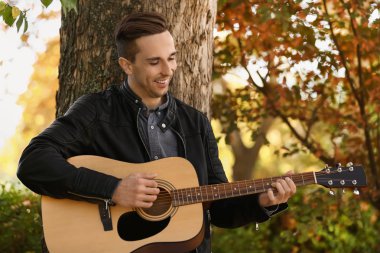 Yakışıklı delikanlı Park'ta dinlenme gitar ile