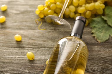 Tahta masada şarap ve üzüm şişesi