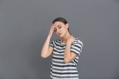 Gri arka plan üzerinde baş ağrısı çeken kadın