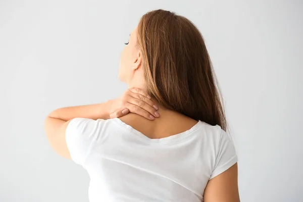Young Woman Suffering Neck Pain Light Background — Stock Photo, Image