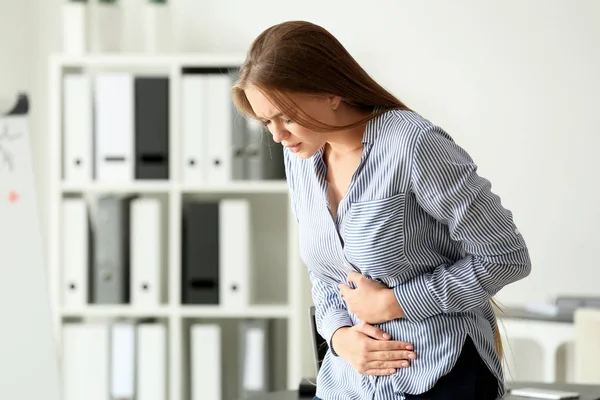 オフィスで腹痛に苦しむ若い女性 — ストック写真