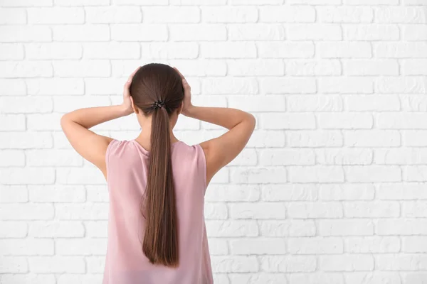 Vrouw Lijden Aan Hoofdpijn Tegen Witte Bakstenen Muur — Stockfoto