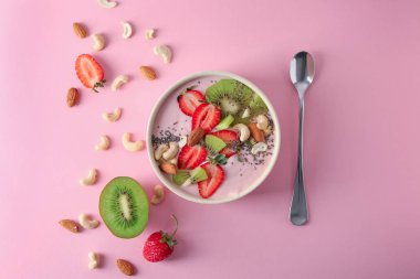 Pembe yoğurt ve renk arka plan üzerinde taze meyve ile kase