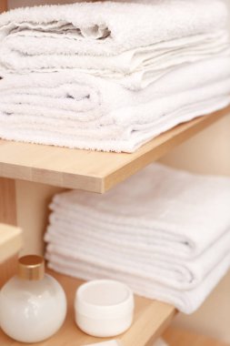 Temiz beyaz havlu ve kozmetik raf kapalı yığını