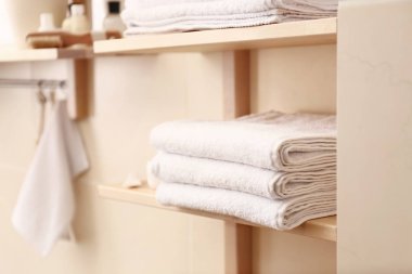 Raf banyoda temiz beyaz havlu yığını