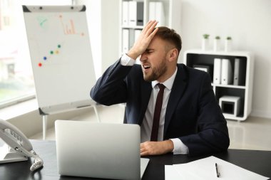 Dizüstü bilgisayar Office ile çalışırken hata yaptıktan sonra duygusal genç işadamı