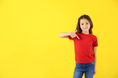Sevimli kız onun t-shirt renk arka plan üzerine işaret