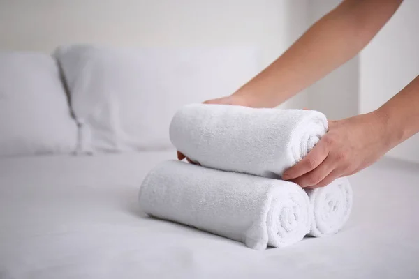 妇女把干净的白色毛巾放在床上在室内 — 图库照片