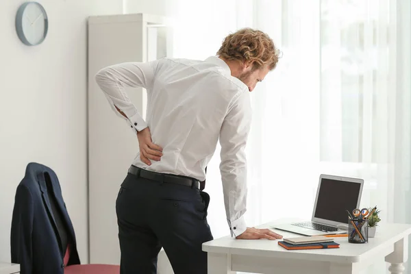 オフィスでの背中の痛みに苦しむ青年実業家 — ストック写真