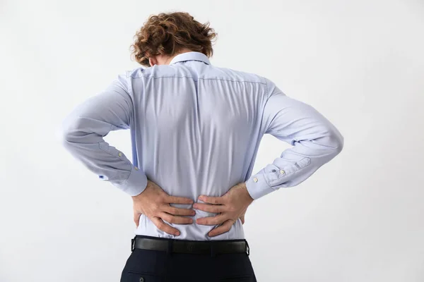Young Man Suffering Back Pain Light Background — Stock Photo, Image