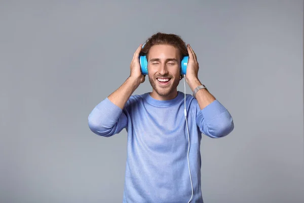 Young Man Listening Music Grey Background — Stock Photo, Image