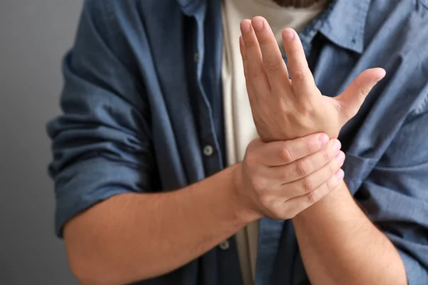 Homem Que Sofre Dor Pulso Fundo Cinza Close — Fotografia de Stock