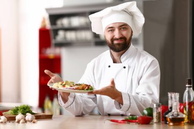 Mutfakta lezzetli yemekleri olan erkek aşçı.