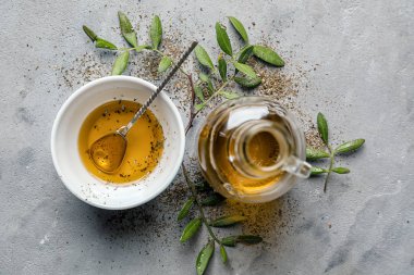 Kase ve gri arka plan üzerine zeytinyağı şişesi