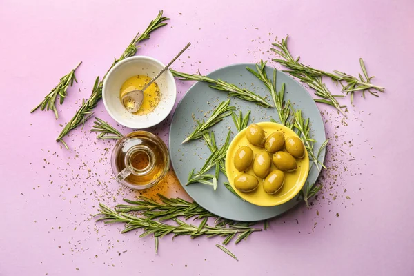 Composition with olive oil and rosemary on color background