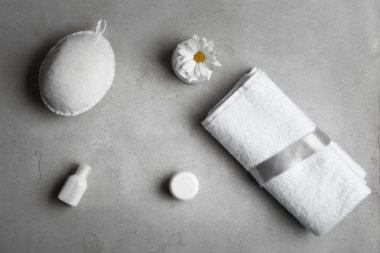 Temiz yumuşak bir havlu ile gri arka plan üzerinde kozmetik