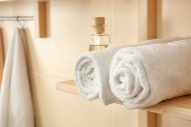 Temiz yumuşak havlu raf banyoda haddelenmiş