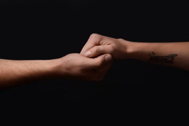 Erkek ve kadın koyu arka plan üzerinde elele