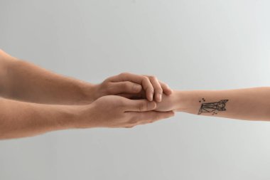 Adam kadının elini tutarak açık renkli