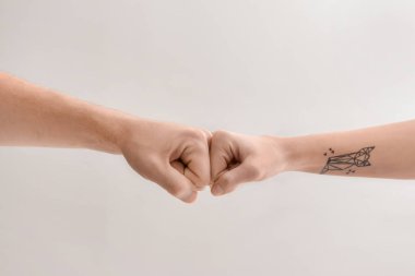 Man and woman making fist bump gesture on light background clipart