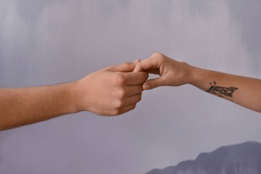 erkek ve kadın gri arka plan üzerine elele