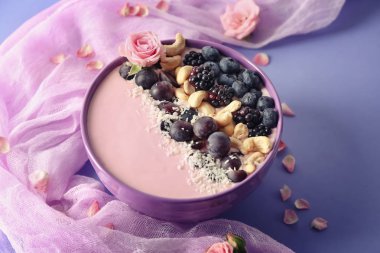 Pembe yoğurt, fındık ve taze meyve renk arka plan üzerinde kase