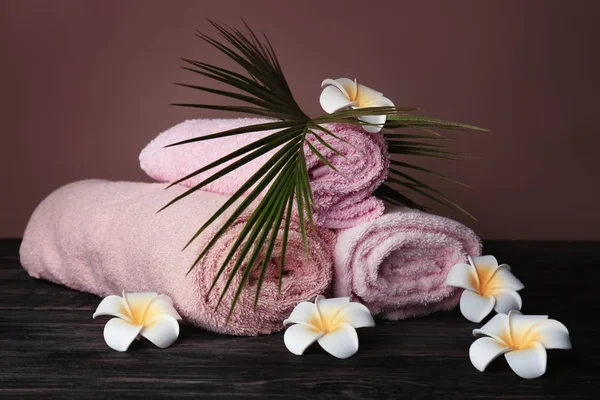 Rolled Clean Soft Towels Flowers Tropical Leaf Dark Wooden Table — Stock Photo, Image
